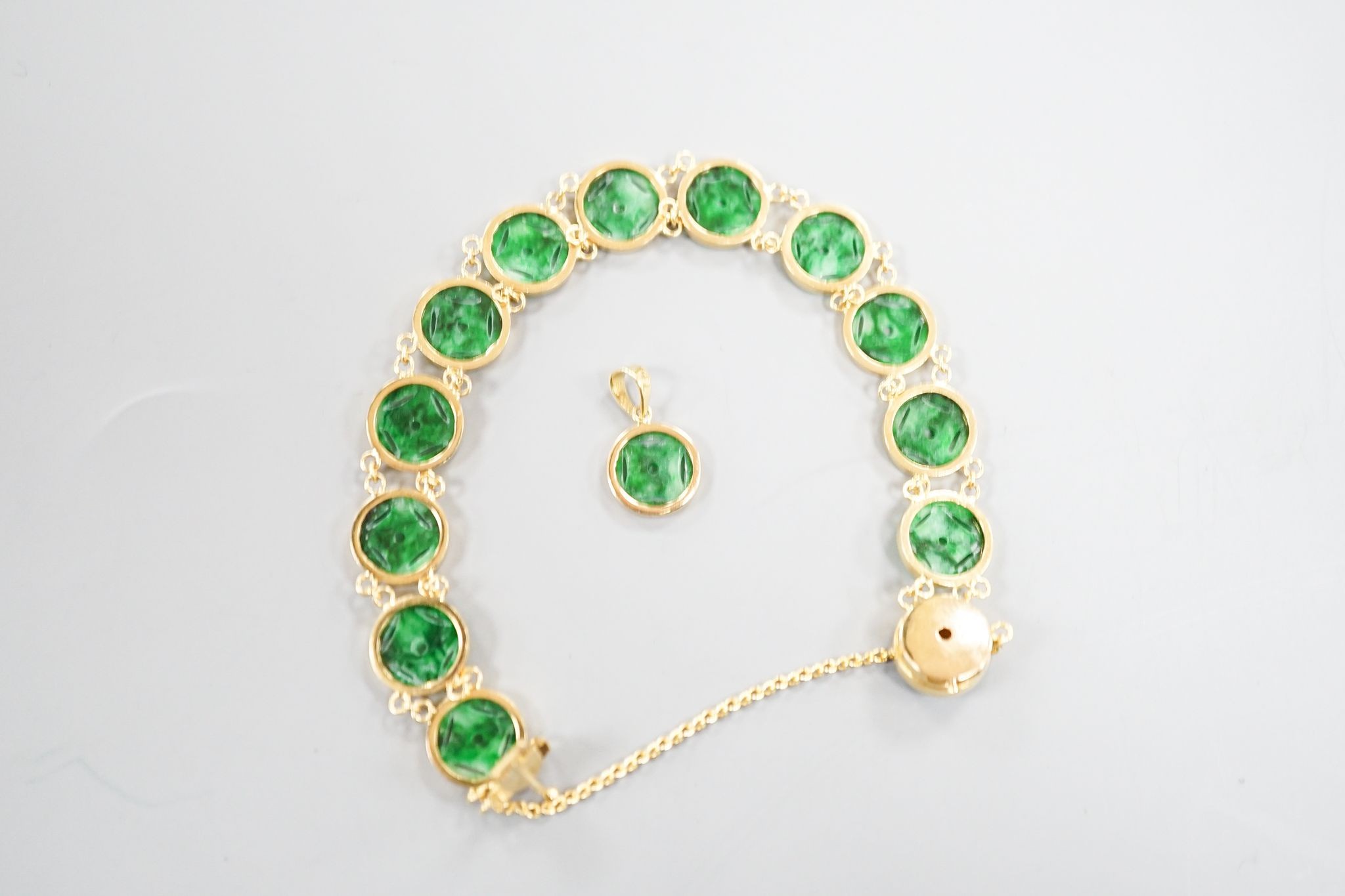 A Chinese 850 yellow metal and jade disc bracelet, 15cm and a matching small pendant, gross 9.7 grams.